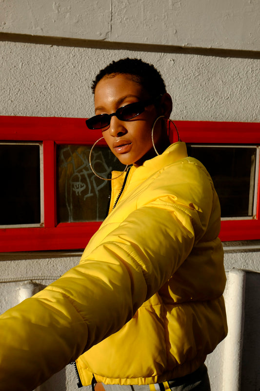 a woman in a yellow jacket and sunglasses