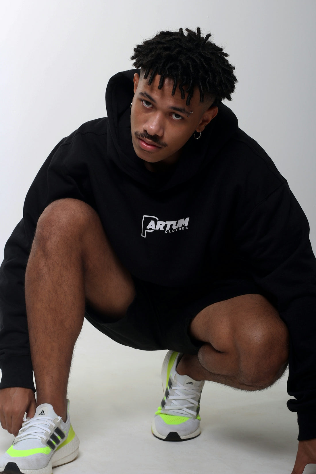 a man in a black hoodie crouching down
